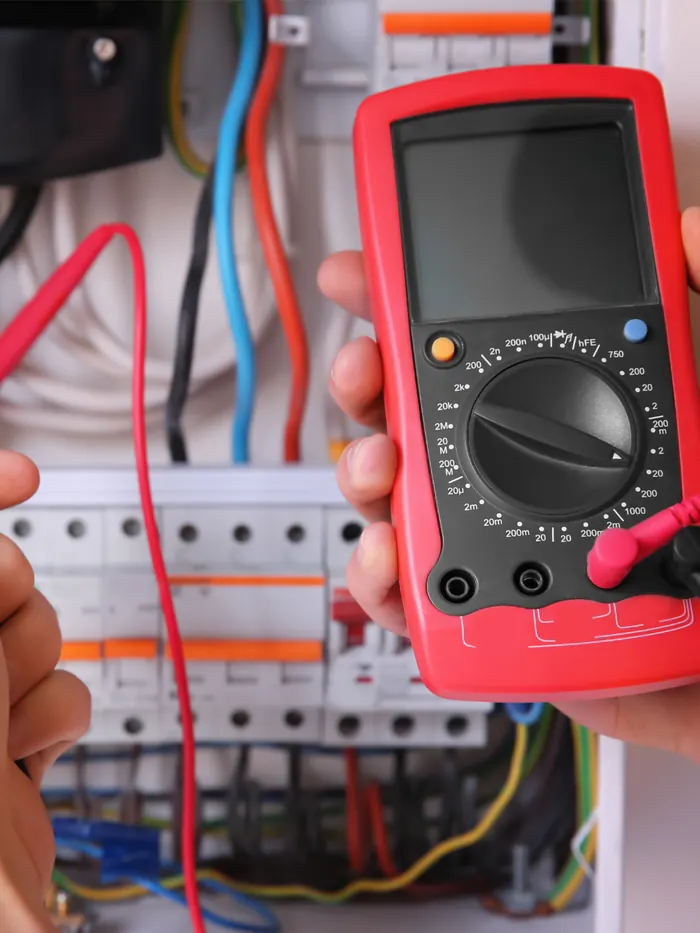 Técnico midiendo un tablero eléctrico con multímetro